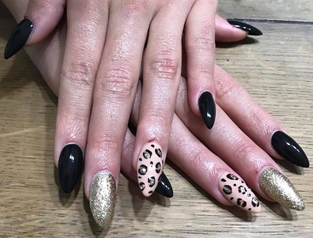 Unghie nere e dorate con decoro leopardato glitterato