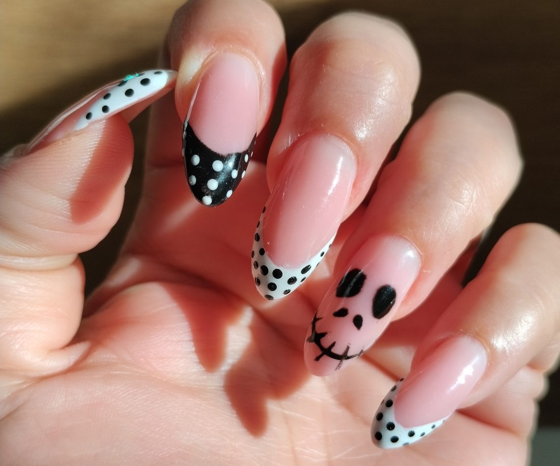 Unghie bianche e nere a pois con decoro a teschio